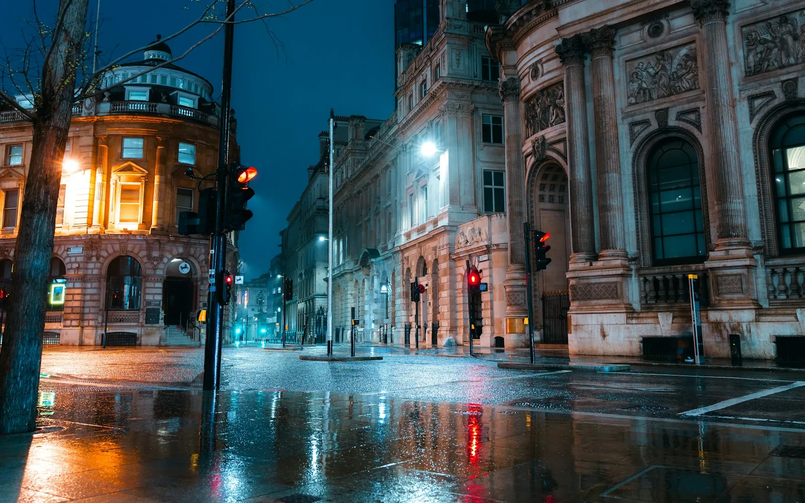 An empty city intersection reflecting lights after rain